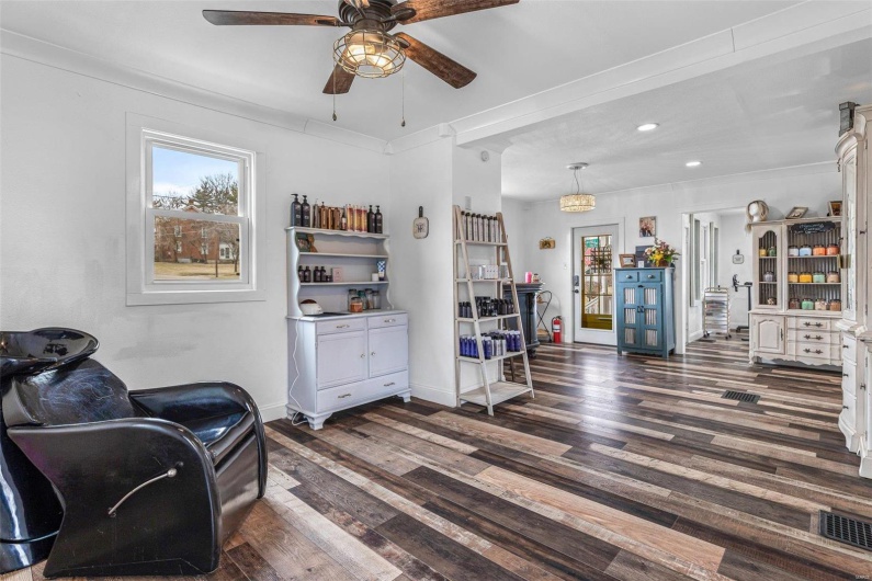 Sitting room featuring a healthy amount of sunlight, baseboards, and dark wood-style flooring