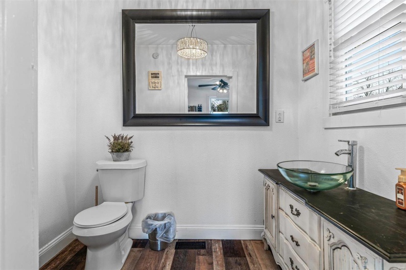 Bathroom with visible vents, toilet, vanity, wood finished floors, and baseboards