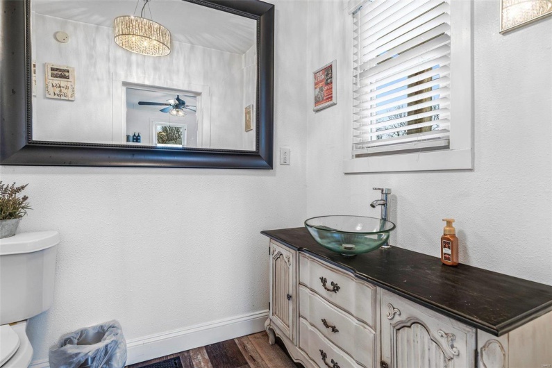Half bathroom featuring toilet, ceiling fan, vanity, wood finished floors, and baseboards