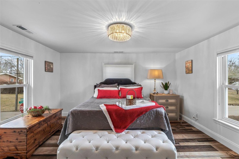 Bedroom featuring visible vents, baseboards, and wood finished floors