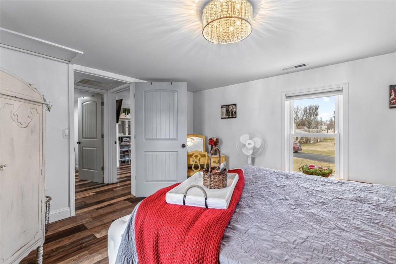 Bedroom with wood finished floors, visible vents, and a notable chandelier