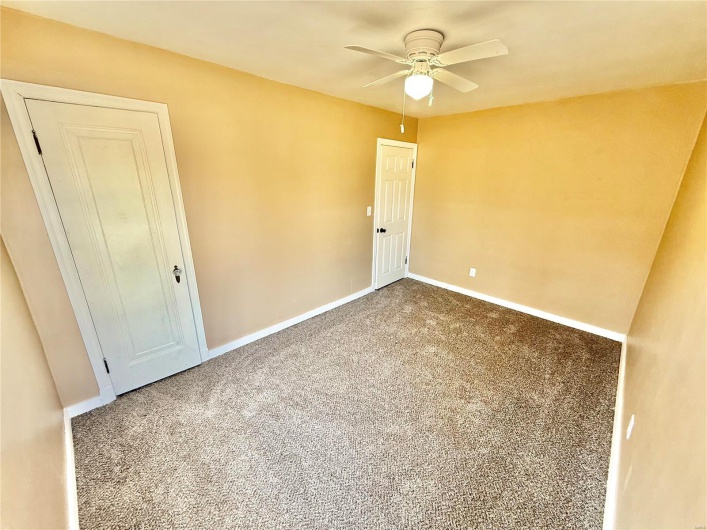Empty room featuring ceiling fan, baseboards, and carpet flooring