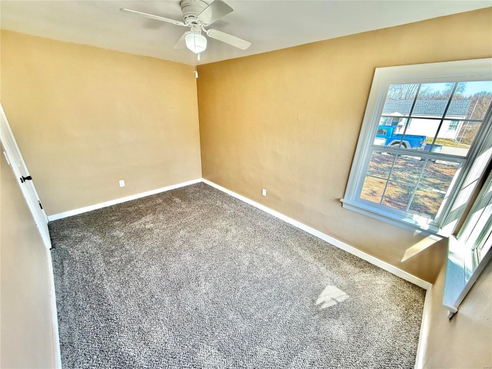 Spare room featuring carpet, baseboards, and a ceiling fan