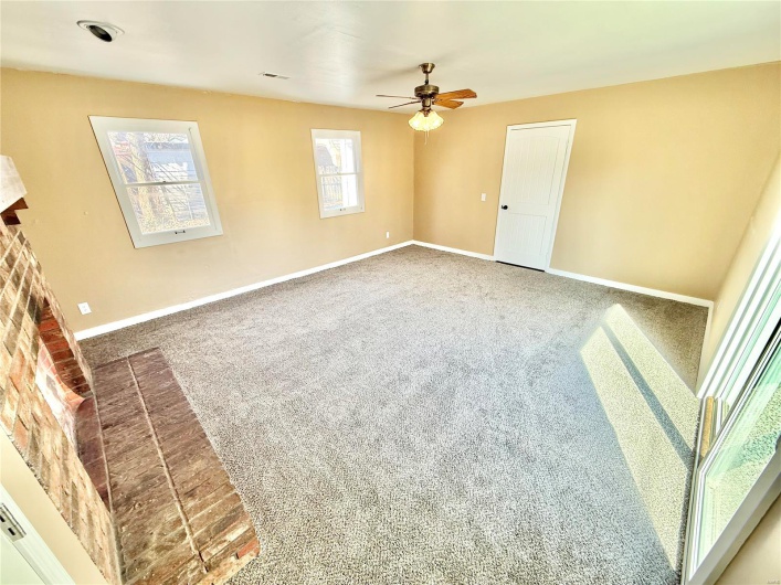 Carpeted spare room featuring visible vents, baseboards, and a ceiling fan