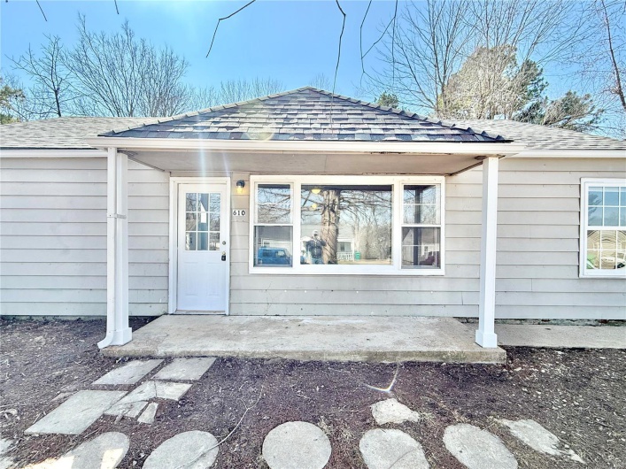 View of exterior entry with roof with shingles