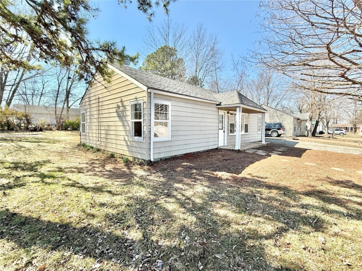 View of side of property with roof with shingles