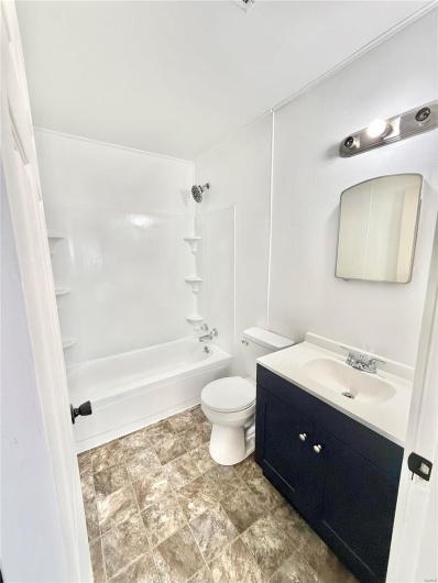 Bathroom with toilet, shower / washtub combination, and vanity
