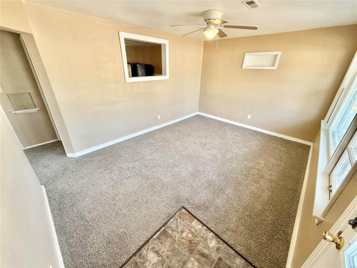 Unfurnished room with carpet floors, baseboards, visible vents, and a ceiling fan
