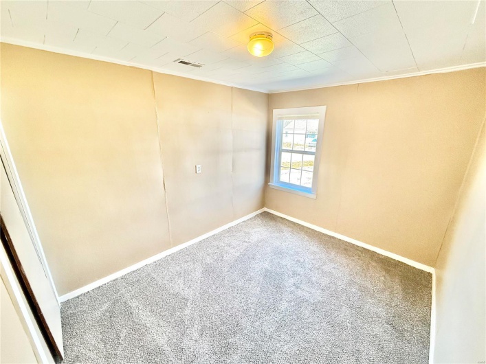 Carpeted spare room featuring ornamental molding, visible vents, and baseboards