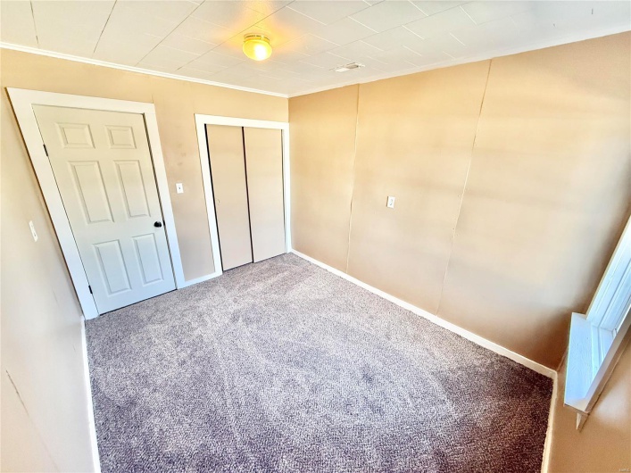 Unfurnished bedroom with baseboards, carpet floors, a closet, and crown molding