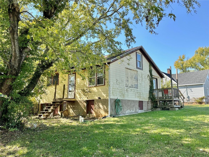 Back of property with a lawn