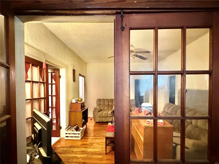 Doorway to outside featuring ceiling fan, hardwood / wood-style flooring, and a textured ceiling