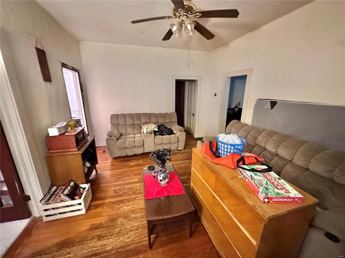 Living room with ceiling fan and hardwood / wood-style floors