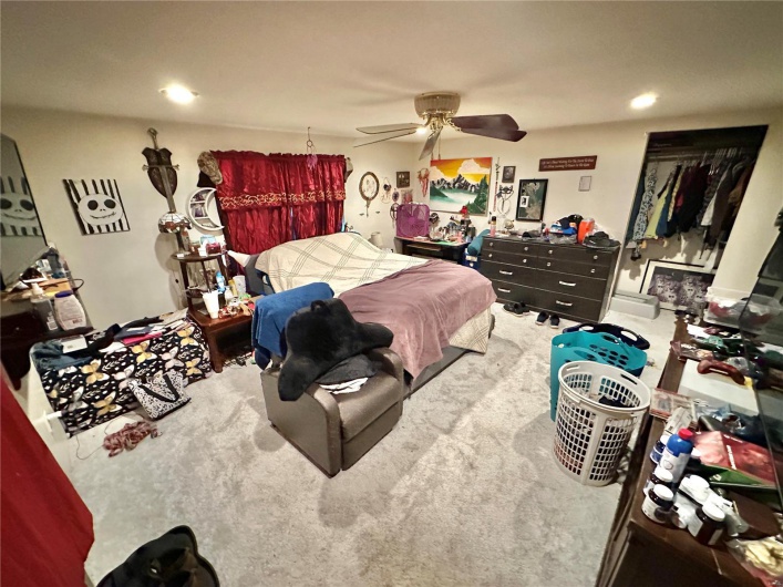 Carpeted bedroom featuring ceiling fan