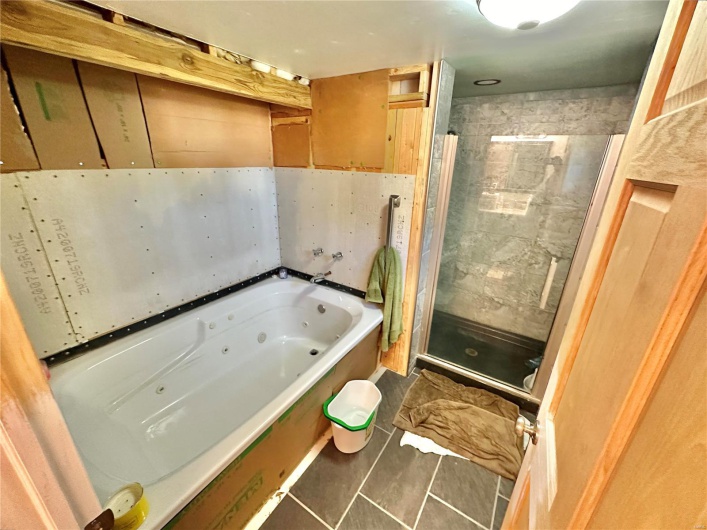 Bathroom featuring independent shower and bath and tile patterned flooring