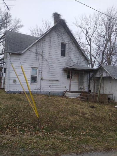 Side view of property featuring a shingled roof and a lawn