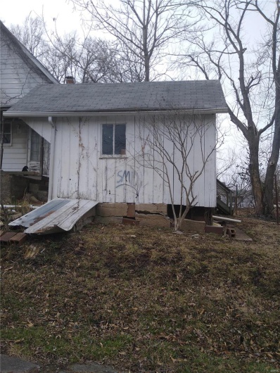 View of property exterior featuring a chimney and roof with shingles
