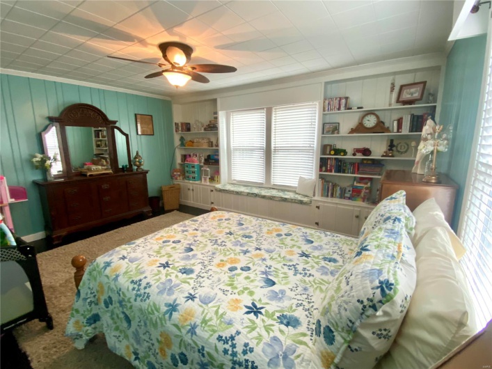 Bedroom with ceiling fan and built ins