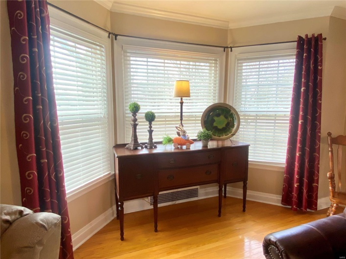 Sitting room featuring a wealth of natural light, baseboards, light wood finished floors, and crown molding