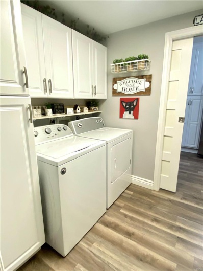 laundry room featuring baseboards, cabinet space, light wood finished floors, and separate washer and dryer