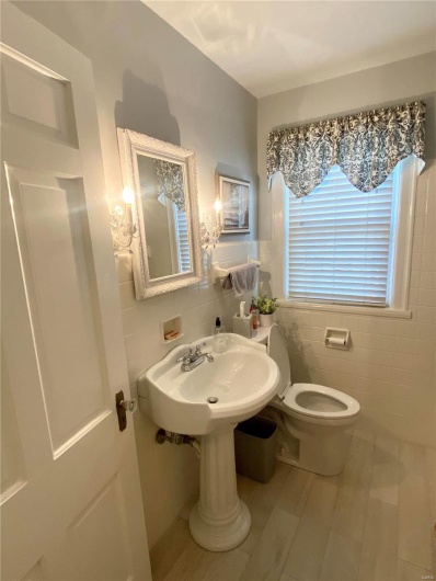 Bathroom featuring toilet, a sink, and tile walls