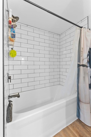 Bathroom with hardwood / wood-style floors and shower / bath combo