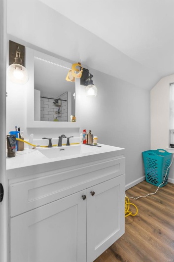 Bathroom featuring walk in shower, vanity, and hardwood / wood-style flooring