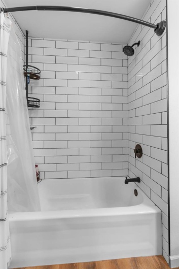 Bathroom featuring shower / bath combination with curtain and hardwood / wood-style flooring