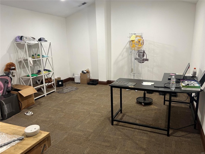 Office space with carpet, visible vents, and baseboards