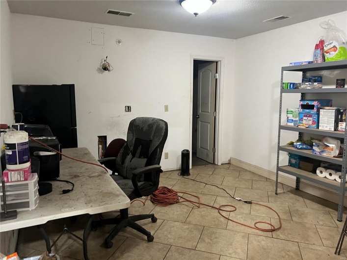Tiled home office featuring visible vents