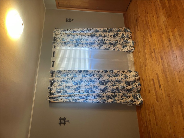Spare room with wood finished floors, crown molding, and baseboards