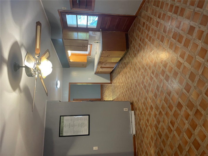 Kitchen featuring light floors, light countertops, ceiling fan, and baseboards