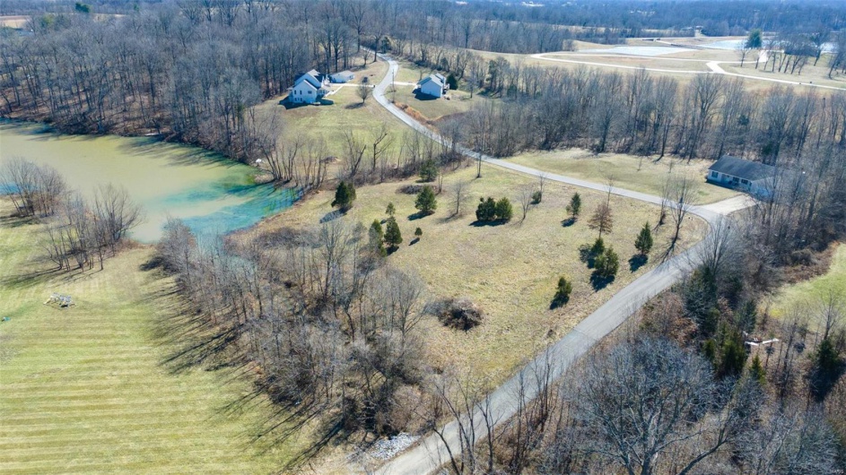 Bird's eye view featuring a rural view, a water view, and a view of trees