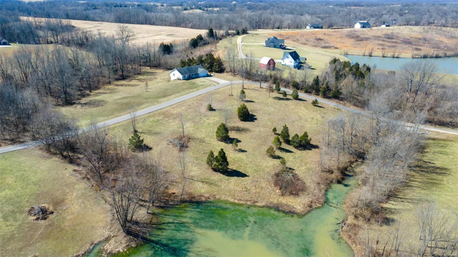 Birds eye view of property featuring a water view and a rural view