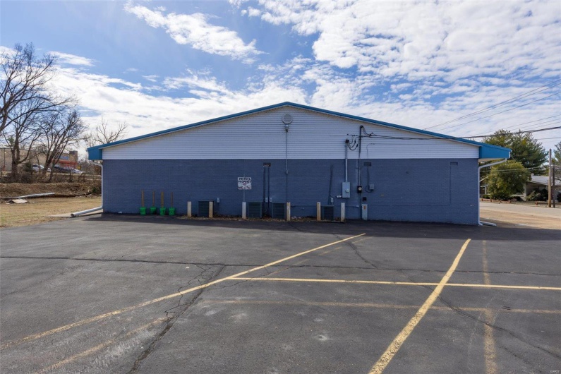 View of building exterior with uncovered parking