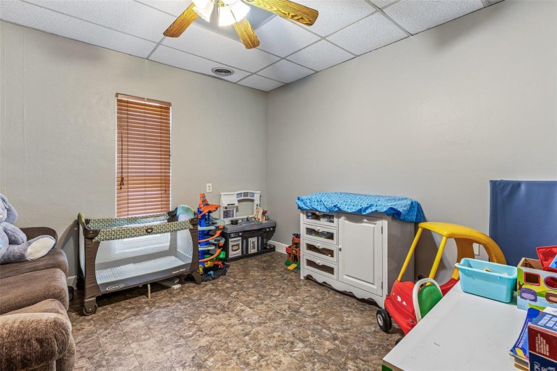 Recreation room featuring ceiling fan, visible vents, and a drop ceiling