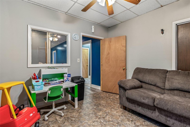 Office space featuring a drop ceiling and a ceiling fan