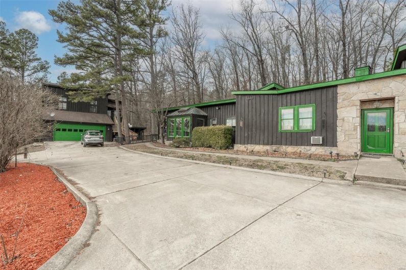View of front of property with stone siding, board and batten siding, and concrete driveway