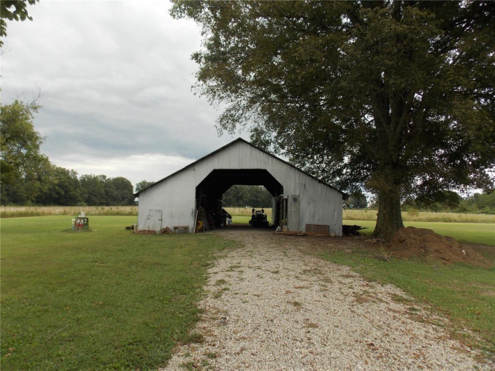 View of pole building with a lawn and driveway