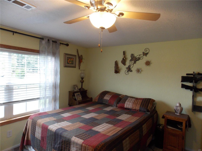 Bedroom with visible vents and a ceiling fan