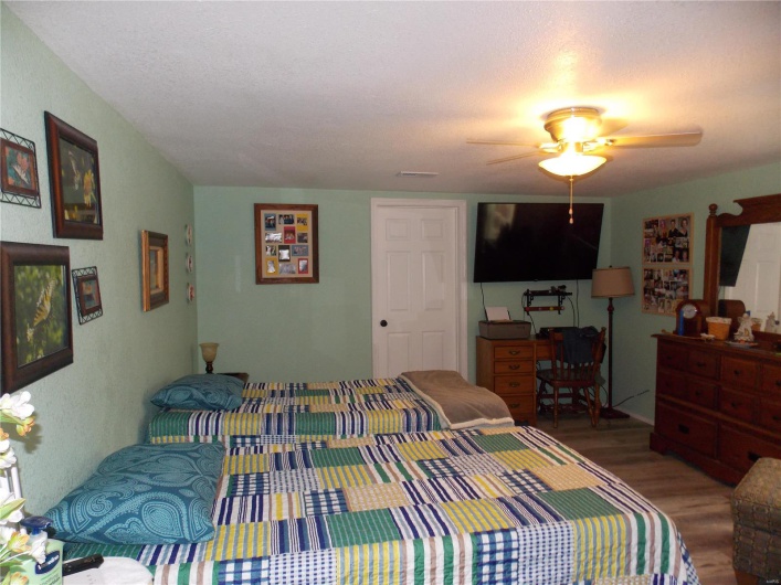 Bedroom featuring visible vents, ceiling fan, and wood finished floors