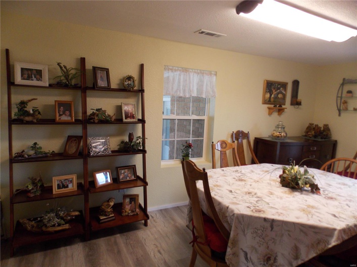 Dining area with wood finished floors, visible vents, and baseboards