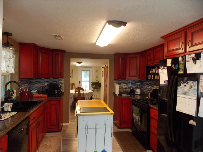 Kitchen featuring a sink, visible vents, black appliances, and dark brown cabinets