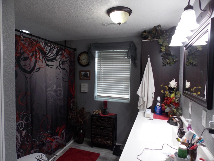 Bedroom featuring a sink, visible vents, and a textured ceiling