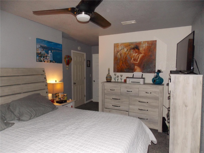 Bedroom featuring visible vents, a ceiling fan, and carpet flooring