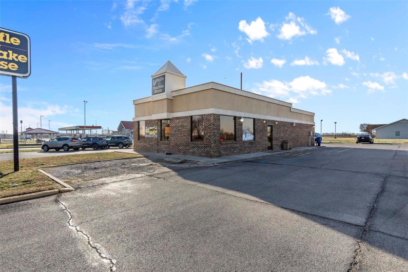 View of building exterior with uncovered parking