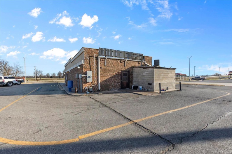 View of property with cooling unit and uncovered parking
