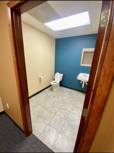 Bathroom with toilet, baseboards, and a sink
