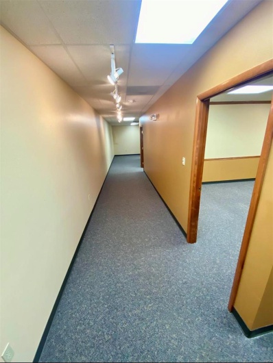 Corridor with a paneled ceiling and rail lighting