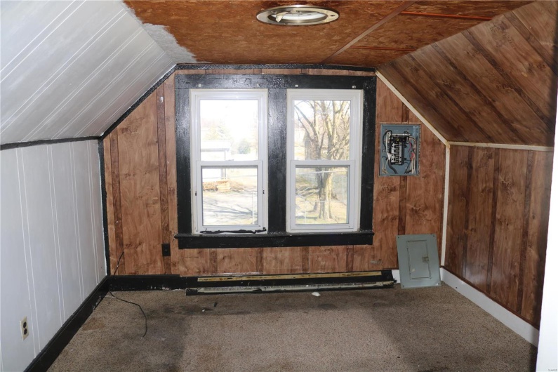 Upstairs Bedroom #1 featuring carpet flooring, wood walls, lofted ceiling, and a baseboard radiator